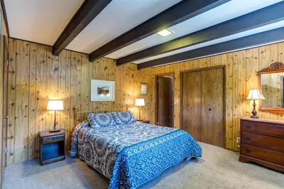 a bedroom with a bed and a wooden wall at Bird's Eye View in Yosemite West