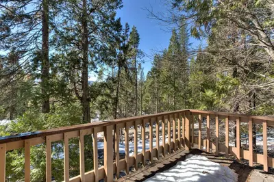 a wooden bridge in the woods with snow on the ground at Bird's Eye View in Yosemite West
