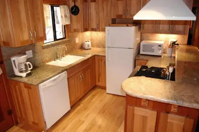 a kitchen with a white refrigerator and a sink at Deer Den in Wawona