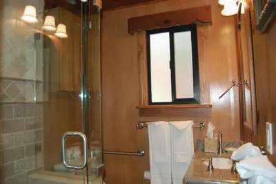 a bathroom with a shower and a sink and a window at Deer Den in Wawona