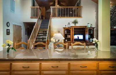 a kitchen with a staircase and a living room at The Terry Cabin in Wawona