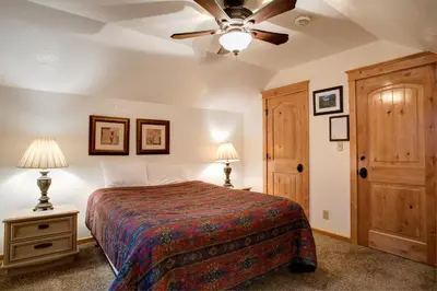 a bedroom with a bed and a ceiling fan at Big Pine Lodge in Wawona