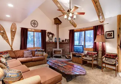 a living room with a couch and a tv at Big Pine Lodge in Wawona