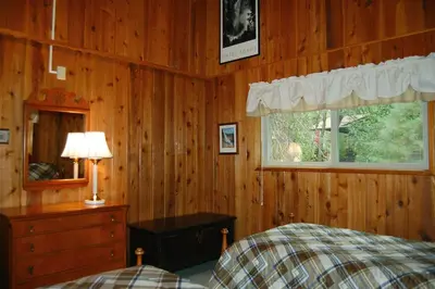 a bedroom with a bed and a dresser and a window at Dunning's Retreat in Wawona