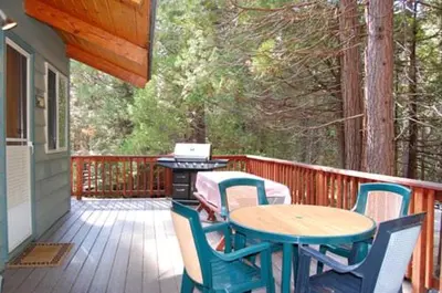 a patio with a table and chairs on a deck at Dunning's Retreat in Wawona