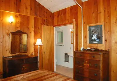 a bedroom with a bed and a dresser and a mirror at Dunning's Retreat in Wawona