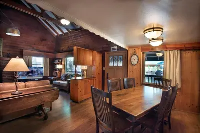a dining room with a wooden table and a couch at Grandma's Cabin in Wawona