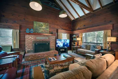a living room with a couch and a fireplace at Grandma's Cabin in Wawona