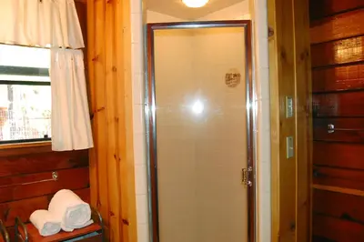 a shower with a glass door in a bathroom at Cubby's Den in Wawona