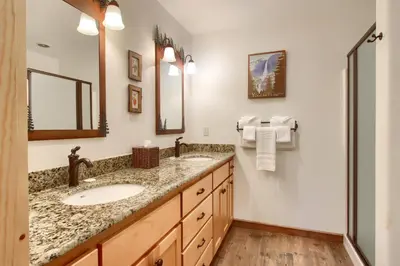 a bathroom with two sinks and a mirror at Larkspur Lair in Wawona