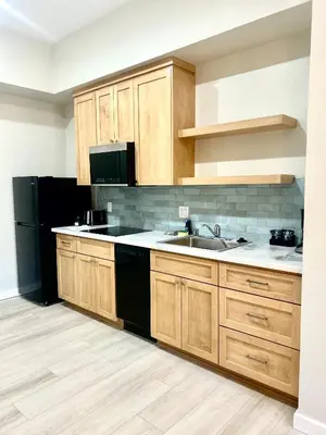 a kitchen with wooden cabinets and a black refrigerator at The Palisades Lodge of Big Pine in Big Pine