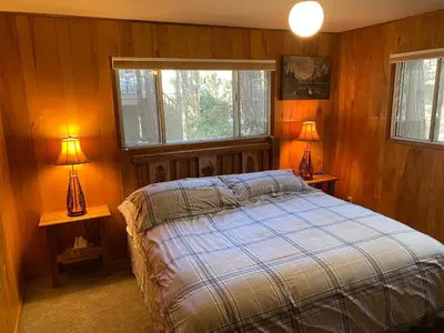 a bedroom with a bed and two lamps on tables at Cutter's Edge in Wawona