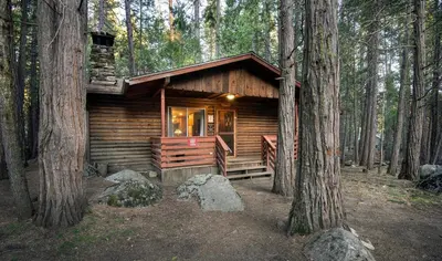 a log cabin in the woods with trees at Pine Creek Cabin in Wawona
