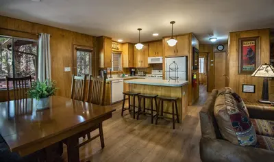 a kitchen and living room with a table and chairs at Pine Creek Cabin in Wawona