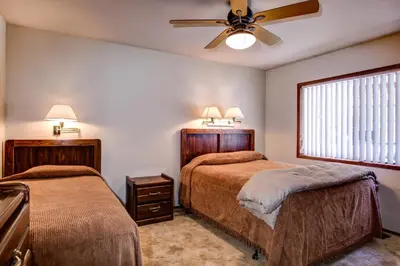 a bedroom with two beds and a ceiling fan at Coyle's Cabin in Wawona