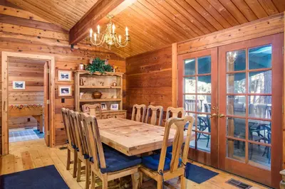a dining room with a wooden table and chairs at Cedar Chalet in Wawona