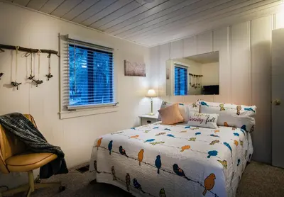 a bedroom with a bed and a chair and a mirror at The Last Resort in Wawona