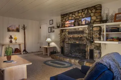 a living room with a stone fireplace and a couch at The Last Resort in Wawona