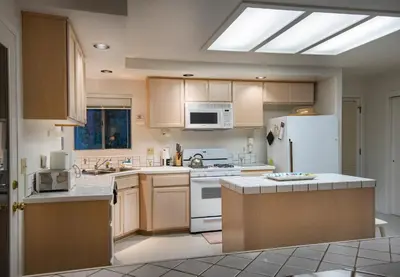 a kitchen with wooden cabinets and a white refrigerator at The Last Resort in Wawona