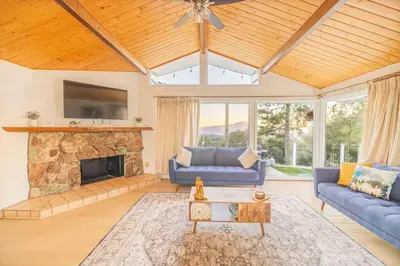 a living room with a stone fireplace and blue couches at Hillside Sky Ranch Retreat 12 miles from Yosemite in Oakhurst