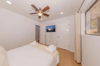 a bedroom with a white bed and a ceiling fan at Hillside Sky Ranch Retreat 12 miles from Yosemite in Oakhurst