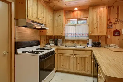 a kitchen with wooden cabinets and a stove top oven at Edna's Hearts Desire in Wawona