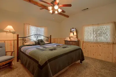 a bedroom with a bed and a ceiling fan at Edna's Hearts Desire in Wawona
