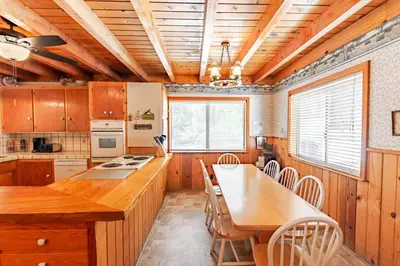 a kitchen with wooden cabinets and a table and chairs at Grant's Camp in Wawona