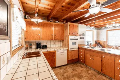 a kitchen with wooden cabinets and a ceiling fan at Grant's Camp in Wawona