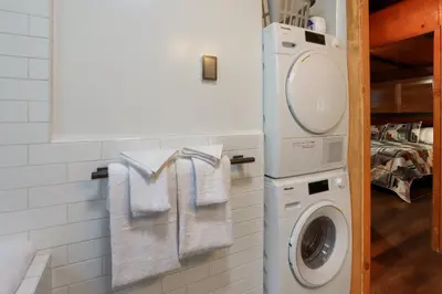 a white laundry room with a washer and dryer at The Overlook in Wawona