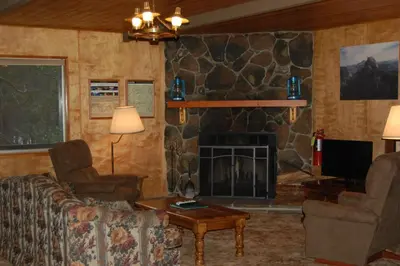 a living room with a couch and a fireplace at Altitude Adjustment in Wawona