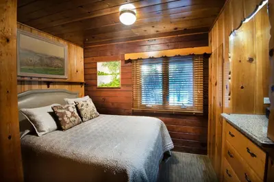 a bedroom with a bed in a wooden cabin at Sugar Pine Suite in Wawona