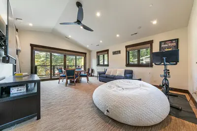 a living room with a large bed and a tv at Aqua Vista Lakefront Estate by Tahoe Getaways - 6 BR in Carnelian Bay w Buoy, Pier & Game Room in Carnelian Bay