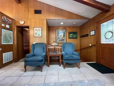 a hallway with two blue chairs and a table at The Tree House II in Wawona