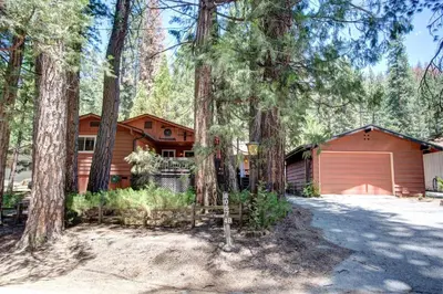 a house in the woods with a garage at Mountain Memory in Wawona