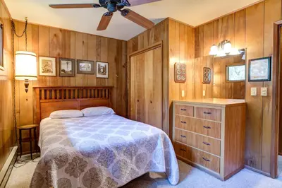 a bedroom with a bed and a wooden wall at Mountain Memory in Wawona