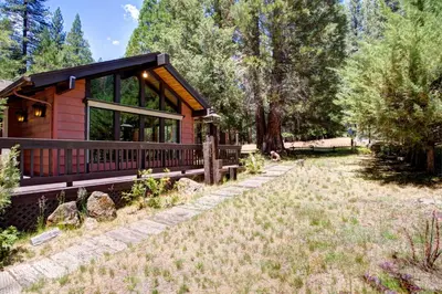 a cabin in the woods with a yard at Mountain Memory in Wawona
