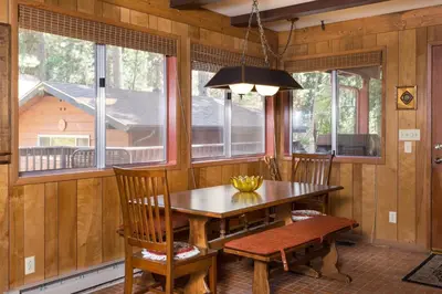 a dining room with a table and chairs and windows at Mountain Memory in Wawona