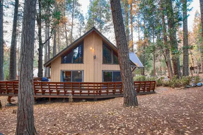 a small cabin in the woods with two trees at Spindler's Chalet in Wawona