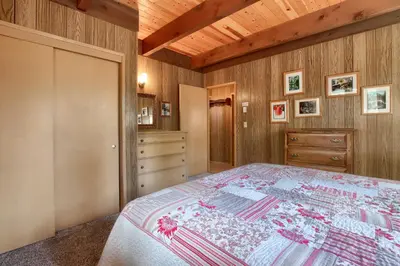 a bedroom with a bed and a wooden ceiling at Spindler's Chalet in Wawona