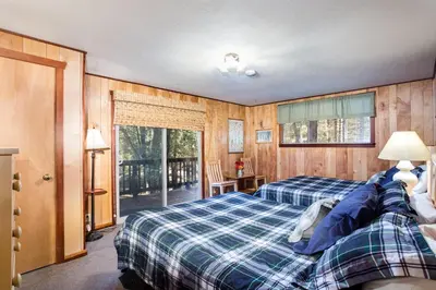 a bedroom with two beds and a balcony at Soots-Me in Wawona