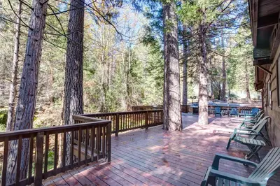 a deck with chairs and trees on a house at Soots-Me in Wawona