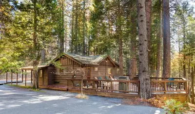 a log cabin in the middle of a forest at Soots-Me in Wawona