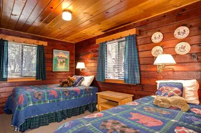 a bedroom with two beds in a log cabin at Mia Mora in Wawona