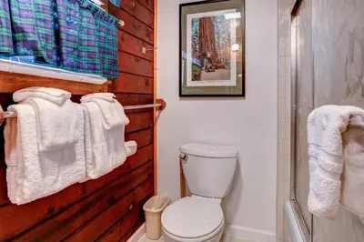 a bathroom with a toilet and towels on a wall at Mia Mora in Wawona