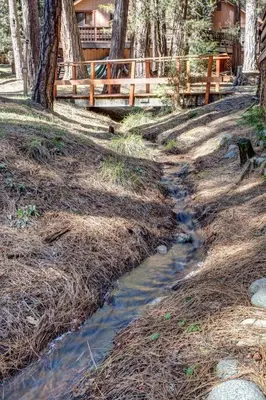 a stream in a yard with a wooden fence at Mia Mora in Wawona