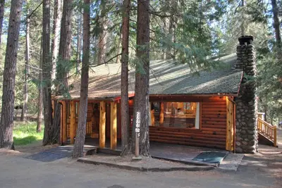 a log cabin in the woods with trees at Tuolumne Meadow in Wawona