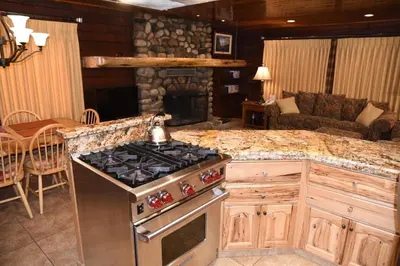 a kitchen with a stove and a living room at Tuolumne Meadow in Wawona