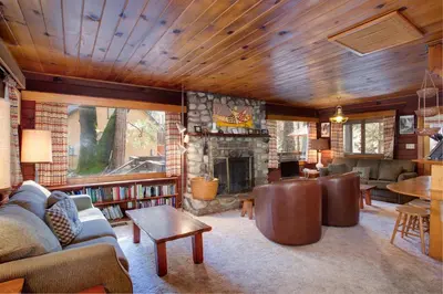 a living room with a couch and a fireplace at Creekside Cabin in Wawona