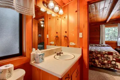 a bathroom with a sink and a bed in a room at Deer Creek in Wawona